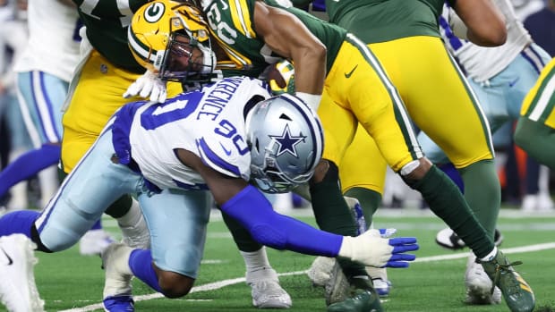 Jan 14, 2024; Arlington, Texas, USA; Dallas Cowboys defensive end DeMarcus Lawrence (90) tackles Green Bay Packers running back Aaron Jones (33) during the first quarter for the 2024 NFC wild card game at AT&T Stadium.
