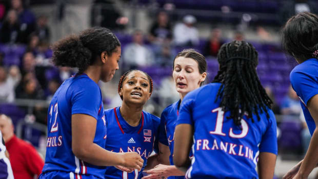 Kansas players huddle during a stoppage in play during a game against TCU.
