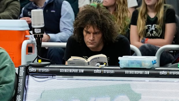 Feb 8, 2024; Milwaukee, Wisconsin, USA; Milwaukee Bucks center Robin Lopez sits at a sideline table and reads a book during the third quarter of the game against the Minnesota Timberwolves at Fiserv Forum.