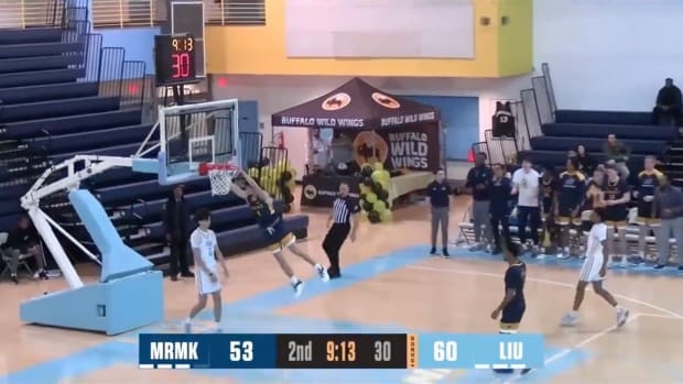 A basketball player hanging from the rim after a dunk as the hoop collapses