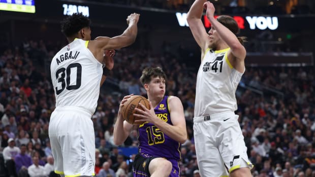 Los Angeles Lakers guard Austin Reaves (15) drives between Utah Jazz guard Ochai Agbaji (30) and forward Kelly Olynyk (41) in the second quarter at Vivint Arena.