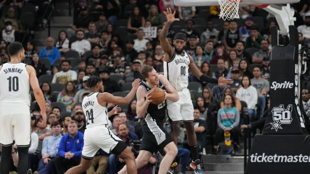San Antonio Spurs center Jakob Poeltl (25) drives in between Brooklyn Nets guard Cam Thomas (24) and forward Royce O'Neale (00) in the second half at the AT&T Center