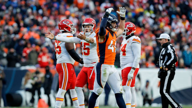 Kansas City Chiefs quarterback Patrick Mahomes (15) reacts as Denver Broncos linebacker Alex Singleton (49) gestures in the fourth quarter at Empower Field at Mile High.