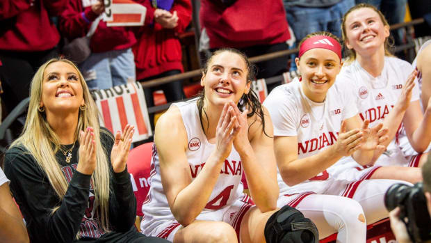 Indiana's Mackenzie Holmes (54) smiles as she watches a video tribute to her with her teammates after the second half of the Indiana versus Purdue women's basketball game at Simon Skjodt Assembly Hall on Sunday, Feb. 11, 2024. Holmes become the all-time leading scorer in the school's history with her 17 points in the game.