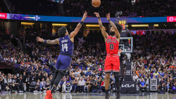 Chicago Bulls guard Coby White (0) shoots the ball over Orlando Magic guard Gary Harris (14) during the second half at KIA Center.