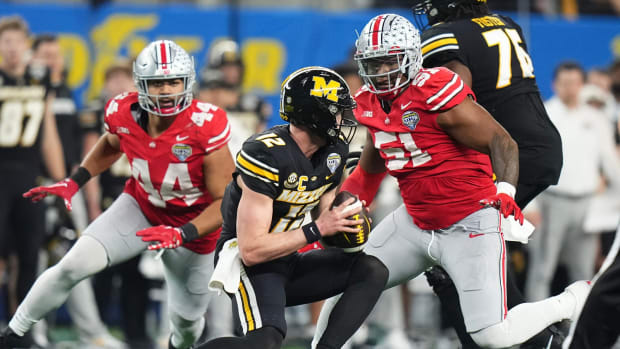 Dec 29, 2023; Arlington, Texas, USA; Ohio State Buckeyes defensive tackle Michael Hall Jr. (51) and defensive end JT Tuimoloau (44) pursue Missouri Tigers quarterback Brady Cook (12) during the third quarter of the Goodyear Cotton Bowl Classic at AT&T Stadium. Ohio State lost 14-3.  