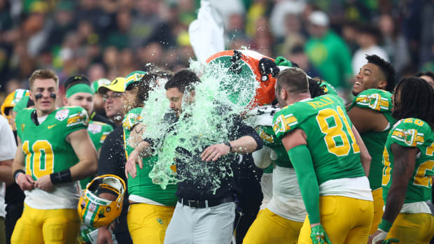 Oregon Ducks head coach Dan Lanning is doused with gatorade on the side at the end of the 2024 Fiesta Bowl against the Liberty Flames at State Farm Stadium.