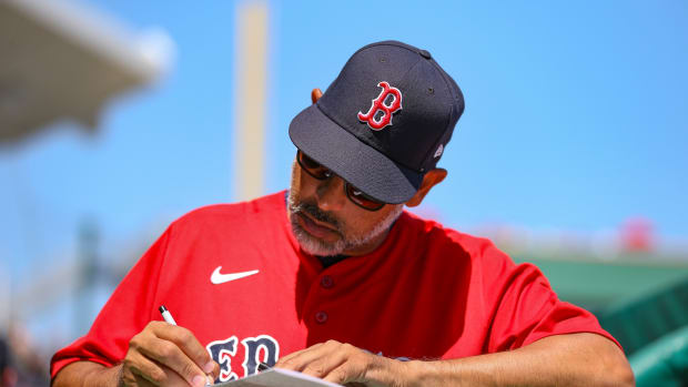 Mar 21, 2022; Fort Myers, Florida, USA; Boston Red Sox manager Alex Cora (13) writes on a scorecard during the game against the Atlanta Braves during spring training at JetBlue Park at Fenway South.