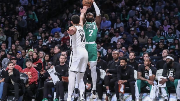 Boston Celtics guard Jaylen Brown (7) takes a three-point shot over Brooklyn Nets guard Ben Simmons (10)