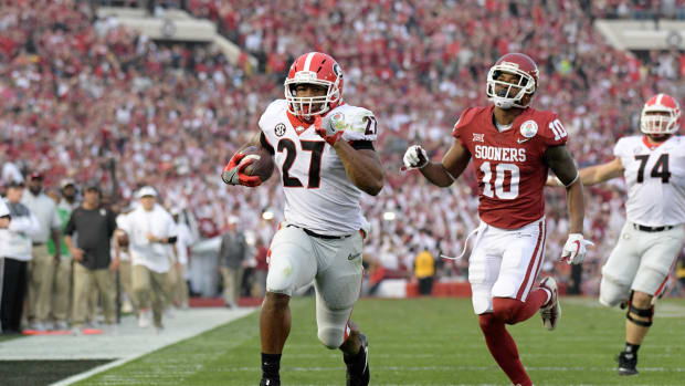 Jan 1, 2018; Pasadena, CA, USA; Georgia Bulldogs running back Nick Chubb (27) is pursued by Oklahoma Sooners defensive back Steven Parker (10) on a 50-yard touchdown run in the third quarter in the 2018 Rose Bowl college football playoff semifinal game at Rose Bowl Stadium. Georgia defeated Oklahoma 54-48 in two overtimes.