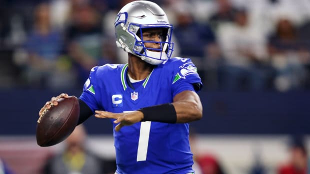 Seahawks quarterback Geno Smith drops back to throw a pass in a game.