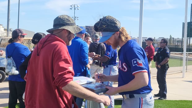 Texas Rangers pitcher Jon Gray signed autographs for fans after the second day of spring training camp on Thursday in Surprise, Ariz.