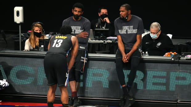 Brooklyn Nets point guard Kyrie Irving (C) and power forward Kevin Durant (R) talk to shooting guard James Harden (13)