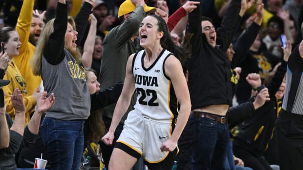 Iowa Hawkeyes guard Caitlin Clark (22) celebrates with fans after breaking the NCAA women's all-time scoring record during the first quarter of a game against the Michigan Wolverines.