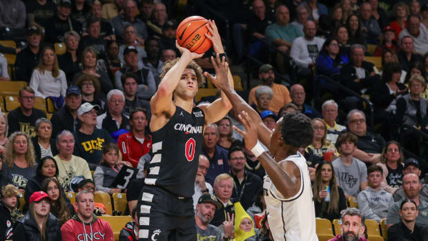 Feb 17, 2024; Orlando, Florida, USA; Cincinnati Bearcats guard Dan Skillings Jr. (0) shoots the ball against UCF Knights forward Marchelus Avery (13) during the first half at Addition Financial Arena. Mandatory Credit: Mike Watters-USA TODAY Sports