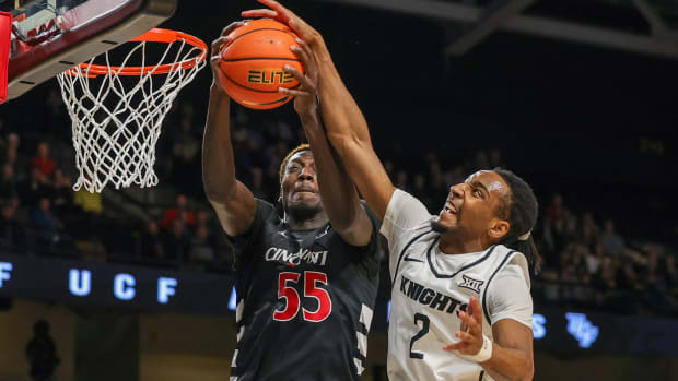 Feb 17, 2024; Orlando, Florida, USA; Cincinnati Bearcats forward Aziz Bandaogo (55) and UCF Knights guard Shemarri Allen (2) battle for the rebound during the first half at Addition Financial Arena. Mandatory Credit: Mike Watters-USA TODAY Sports