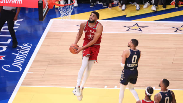 Feb 18, 2024; Indianapolis, Indiana, USA; Western Conference center Karl-Anthony Towns (32) of the Minnesota Timberwolves dunks the ball past Eastern Conference guard Tyrese Halliburton (0) of the Indiana Pacers during the fourth quarter in the 73rd NBA All Star game at Gainbridge Fieldhouse.