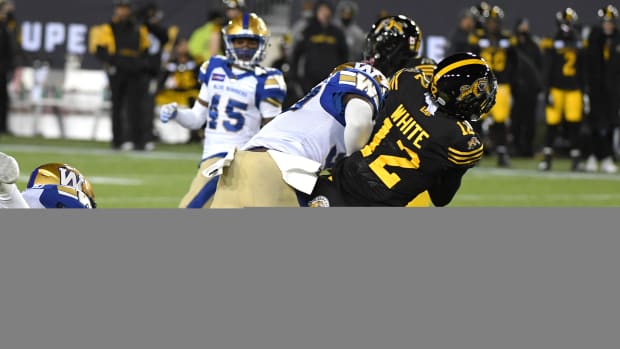 Dec 12, 2021; Hamilton, Ontario, CAN; Hamilton Tiger-Cats wide receiver Tim White (12) is tackled by Winnipeg Blue Bombers defensive back Brandon Alexander (37) during the 108th Grey Cup football game at Tim Hortons Field. Mandatory Credit: Dan Hamilton-USA TODAY Sports  
