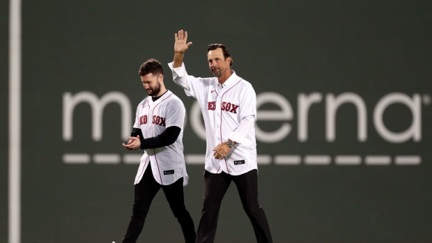 Oct 19, 2021; Boston, Massachusetts, USA; Former Boston Red Sox pitcher Tim Wakefield and singer-songwriter Calum Scott walk onto the field for a ceremonial first pitch before game four of the 2021 ALCS between the Boston Red Sox and the Houston Astros at Fenway Park.