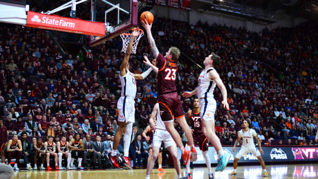 Virginia Tech Hokies guard Tyler Nickel (23) goes in for a layup as Virginia Cavaliers guard Ryan Dunn (13) defends during the second half at Cassell Coliseum.