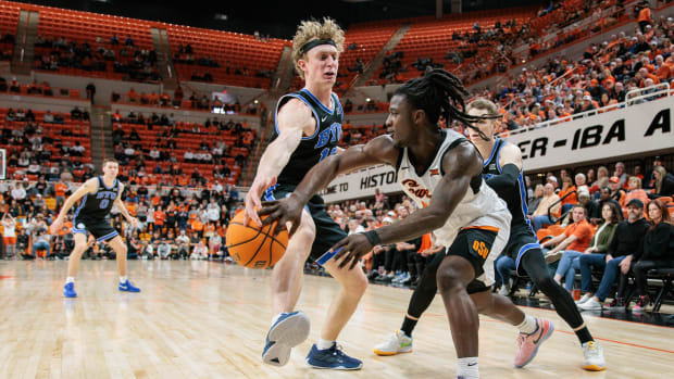 Feb 17, 2024; Stillwater, Oklahoma, USA; Oklahoma State Cowboys guard Javon Small (12) passes the ball around Brigham Young Cougars guard Richie Saunders (15) during the second half at Gallagher-Iba Arena. Mandatory Credit: William Purnell-USA TODAY Sports