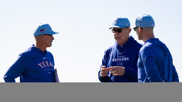 Texas Rangers manager Bruce Bochy, center, with pitching coach Mike Maddux, left, and pitching coach Dave Bush, right, before a spring training workout on Feb. 14.