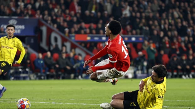 Malik Tillman pictured (center) in mid-air moments after being fouled by Mats Hummels (right) during PSV Eindhoven's 1-1 draw with Borussia Dortmund in February 2024
