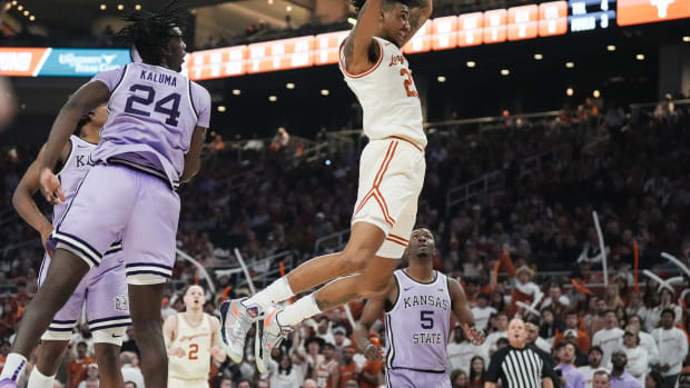Texas Longhorns forward Dillon Mitchell (23) hangs from the basket after dunking as the Longhorns play Kansas State at The Moody Center on Monday, Feb. 19, 2024.
