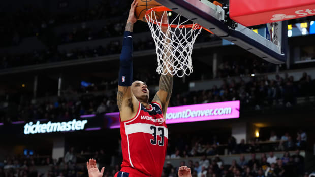 Feb 22, 2024; Denver, Colorado, USA; Washington Wizards forward Kyle Kuzma (33) finishes off a basket in the second half against the Denver Nuggets at Ball Arena. Mandatory Credit: Ron Chenoy-USA TODAY Sports