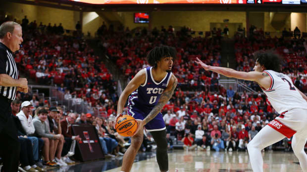 Feb 20, 2024; Lubbock, Texas, USA; TCU Horned Frogs guard Micah Peavy (0) looks to pass the ball around Texas Tech Red Raiders guard Pop Isaacs (2) in the second half at United Supermarkets Arena. Mandatory Credit: Michael C. Johnson-USA TODAY Sports