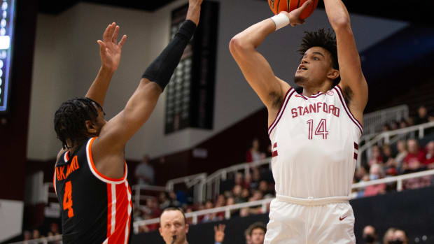 Feb 24, 2024; Stanford, California, USA; Stanford Cardinal forward Spencer Jones (14) attempts a three point basket over Oregon State Beavers guard Dexter Akanno (4) during the first half at Maples Pavilion. Mandatory Credit: D. Ross Cameron-USA TODAY Sports