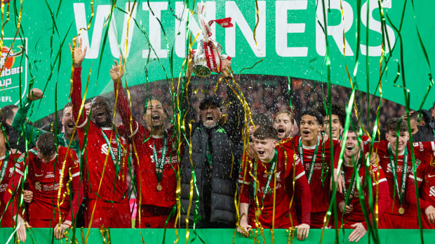 Liverpool manager Jurgen Klopp pictured (center) lifting the EFL Cup trophy following his team's 1-0 win over Chelsea in the 2024 final