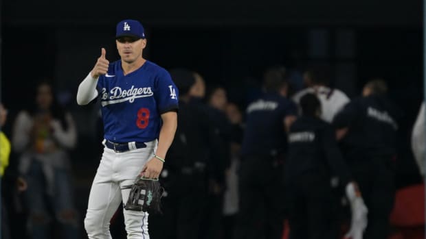 Sep 18, 2023; Los Angeles, California, USA; Los Angeles Dodgers shortstop Enrique Hernandez (8) gestures to the dugout he is ok as security officers apprehend a spectator who ran on to the field during the game against the Detroit Tigers at Dodger Stadium.