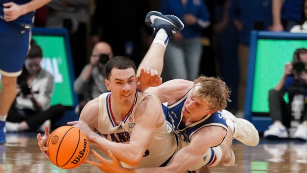 Feb 27, 2024; Lawrence, Kansas, USA; Kansas Jayhawks guard Nicolas Timberlake (25) and Brigham Young Cougars guard Richie Saunders (15) scramble for a loose ball during the second half at Allen Fieldhouse. 