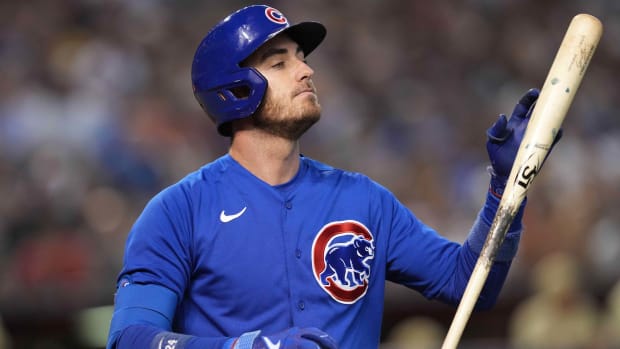 Cubs outfielder Cody Bellinger looks at his bat after striking out