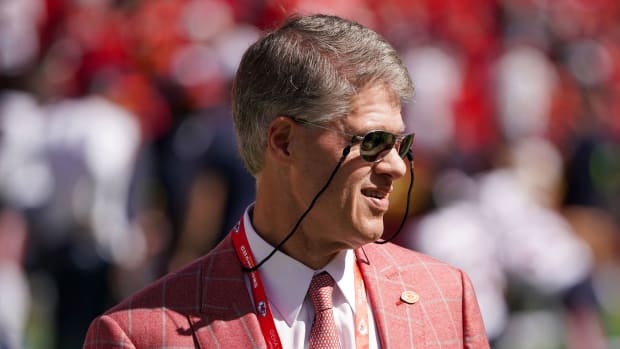 Chiefs owner clark hunt stands on the field looking through sunglasses