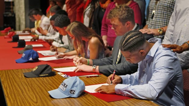 Prospective college athletes, including eight football players, sign their National Letters of Intent on signing day.