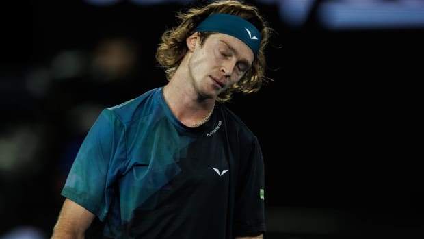 Tennis player Andrey Rublev hangs his head in disappointment during a game.