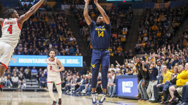 Feb 18, 2023; Morgantown, West Virginia, USA; West Virginia Mountaineers guard Seth Wilson (14) shoots a three-point basket over Texas Tech Red Raiders forward Robert Jennings (4) during the second half at WVU Coliseum.