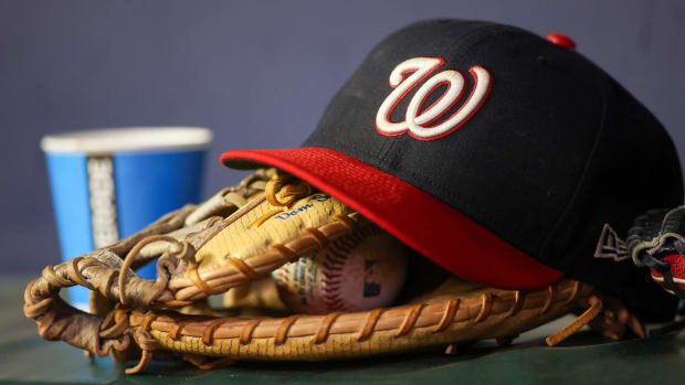 Sep 29, 2023; Atlanta, Georgia, USA; A detailed view of a Washington Nationals hat and glove on the bench against the Atlanta Braves in the third inning at Truist Park.