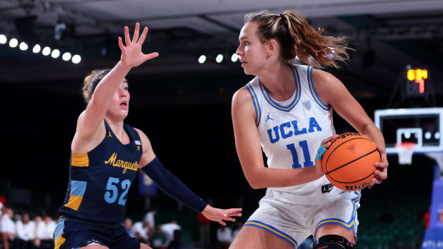 Nov 21, 2022; Paradise Island, BAHAMAS; UCLA Bruins forward Emily Bessoir (11) looks to pass as Marquette Golden Eagles forward Chloe Marotta (52) defends during the first half at Imperial Arena.
