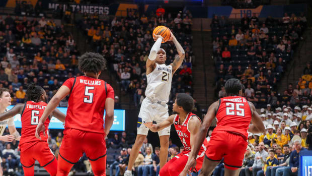 Mountaineers guard RaeQuan Battle (21) shoots a jumper over Texas Tech Red Raiders guard Kerwin Walton (24) during the second half at WVU Coliseum. Mandatory Credit: Ben Queen-USA TODAY Sports