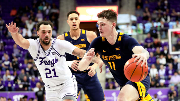 Feb 12, 2024; Fort Worth, Texas, USA; West Virginia Mountaineers forward Quinn Slazinski (11) drives to the basket as TCU Horned Frogs forward JaKobe Coles (21) defends during the second half at Ed and Rae Schollmaier Arena.