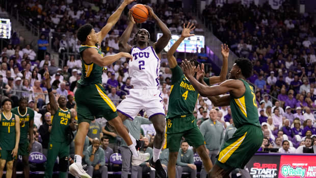 Feb 26, 2024; Fort Worth, Texas, USA; TCU Horned Frogs forward Emanuel Miller (2) drives to the basket on Baylor Bears guard RayJ Dennis (10) and guard Ja'Kobe Walter (4) during the first half at Ed and Rae Schollmaier Arena. 