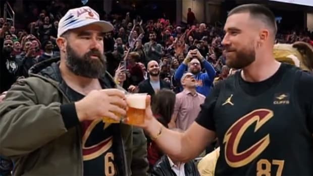 Jason Kelce and Travis Kelce prepare to chug beers at a Cavs game.