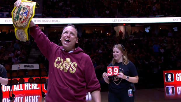 Joey Chestnut celebrates winning an eating contest during halftime.