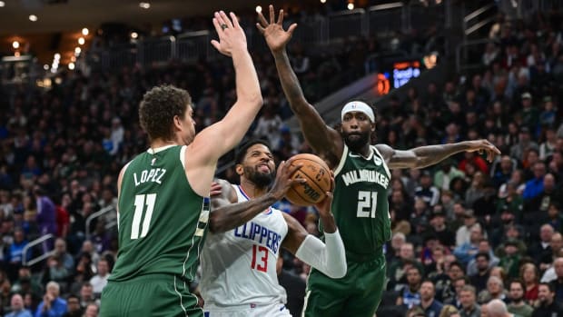 Los Angeles Clippers forward Paul George (13) takes a shot between Milwaukee Bucks center Brook Lopez (11) and guard Patrick Beverley (21) in the second quarter at Fiserv Forum in Milwaukee on March 4, 2024.