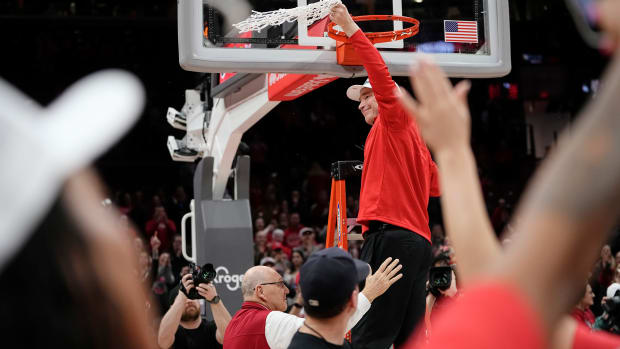 Ohio State Buckeyes head coach Kevin McGuff cuts down the net as the team celebrates winning the Big Ten regular season title after the 67-51 win over the Michigan Wolverines in the NCAA women s basketball game at Value City Arena.
