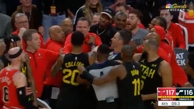 Jazz forward John Collins shoves Bulls assistant coach Chris Fleming during a sideline scuffle.