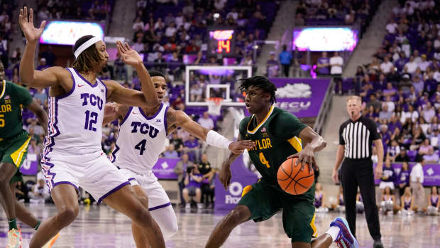Feb 26, 2024; Fort Worth, Texas, USA; Baylor Bears guard Ja'Kobe Walter (4) dribbles against TCU Horned Frogs forward Xavier Cork (12) and guard Jameer Nelson Jr. (4) during the second half at Ed and Rae Schollmaier Arena. 